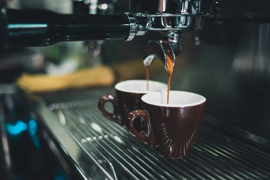 two mugs of espresso being filled