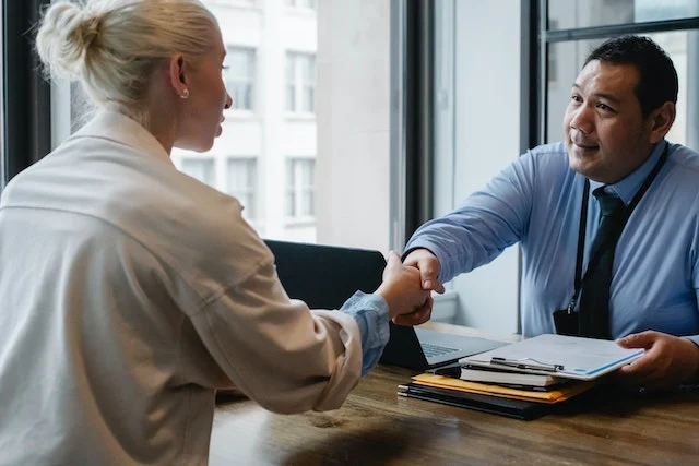Two people shaking hands as if they just negotiated a real estate agreement